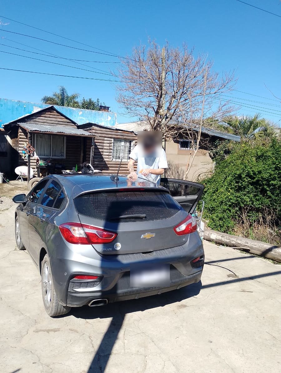 Dando las terminaciones a un Chevrolet Cruze gris en el patio