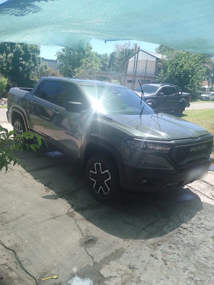 Una camioneta Ram verde oscura recién lavada bajo la media sombra